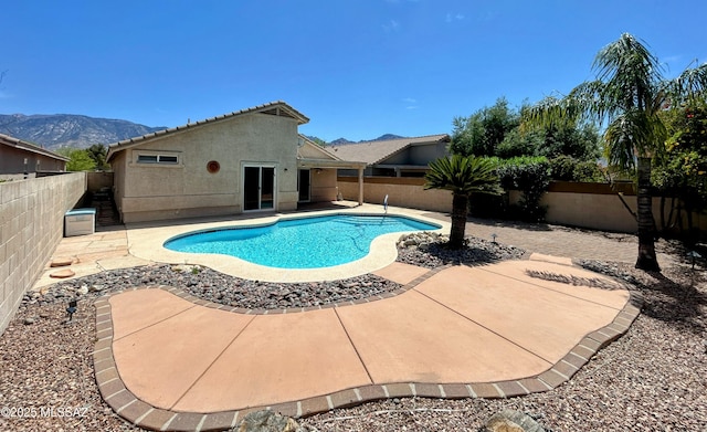 view of swimming pool featuring a fenced in pool, a patio area, a fenced backyard, and a mountain view