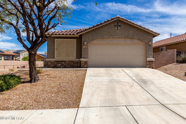 7483 S Salt Water Dr, Tucson, AZ 85757 - view of front facade with an attached garage, fence, stucco siding, stone siding, and driveway