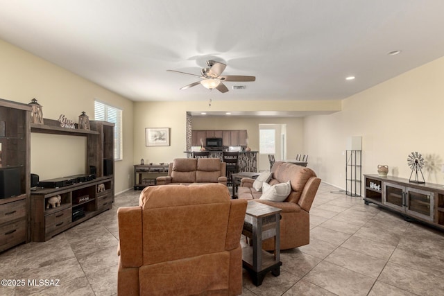 7483 S Salt Water Dr, Tucson, AZ 85757 - living room featuring light tile patterned flooring, a ceiling fan, and visible vents