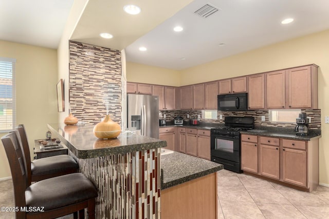 7483 S Salt Water Dr, Tucson, AZ 85757 - kitchen with visible vents, black appliances, a kitchen breakfast bar, tasteful backsplash, and a peninsula