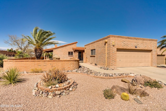 view of front of home with a garage, brick siding, driveway, and fence