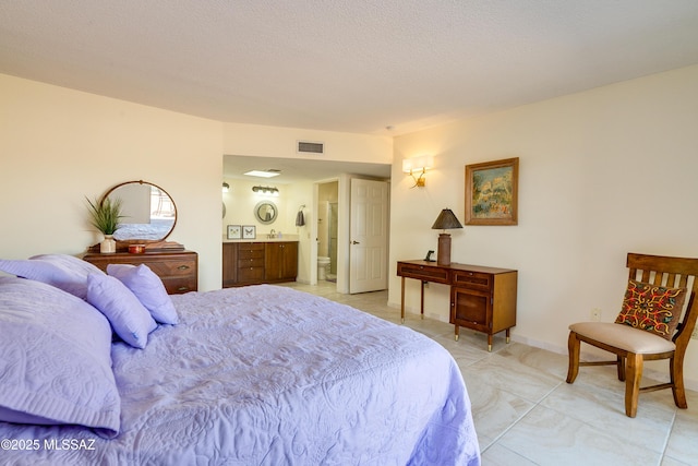 bedroom with visible vents, a textured ceiling, connected bathroom, light tile patterned floors, and baseboards