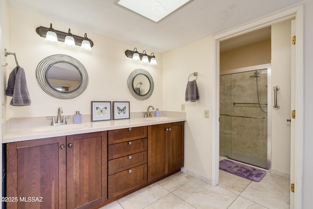 bathroom with double vanity, baseboards, a stall shower, and a sink
