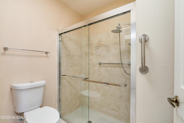 bathroom featuring a shower stall and toilet