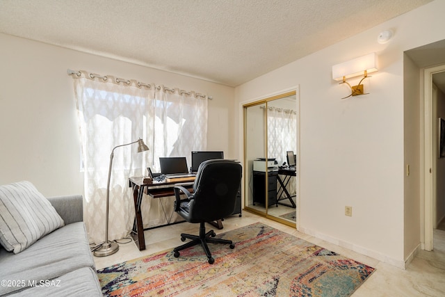 home office featuring baseboards and a textured ceiling