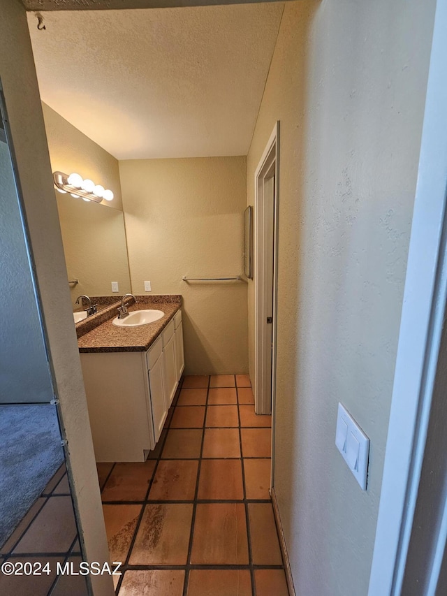 bathroom featuring tile patterned floors, a textured ceiling, and vanity