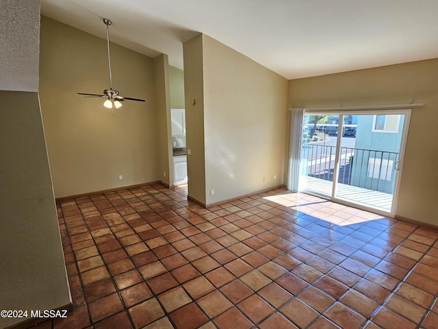 tiled empty room with baseboards, ceiling fan, and vaulted ceiling