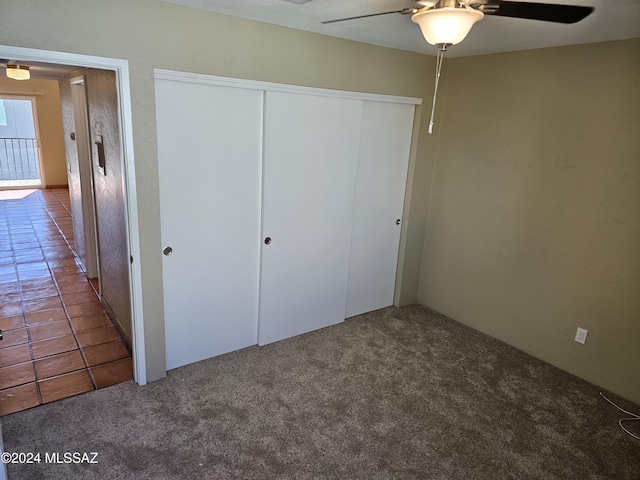 unfurnished bedroom with a closet, ceiling fan, and carpet