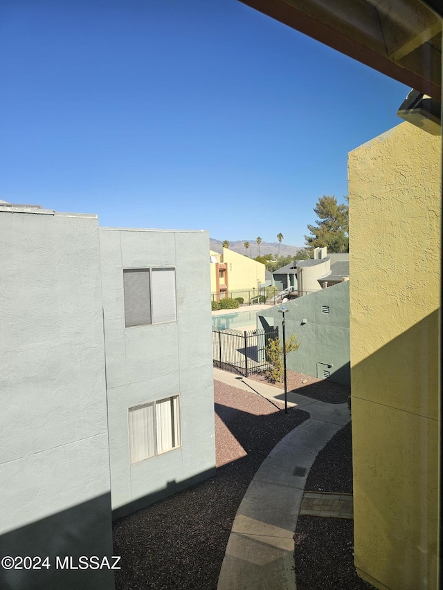 exterior space featuring a pool, a residential view, stucco siding, and fence