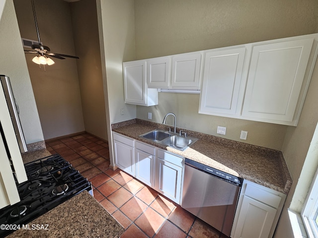 kitchen featuring a ceiling fan, a sink, white cabinets, stainless steel dishwasher, and dark countertops
