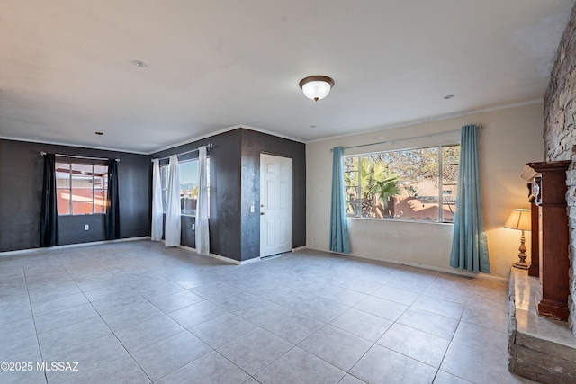 tiled spare room with baseboards and crown molding