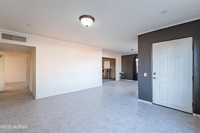 spare room featuring light tile patterned floors, visible vents, and baseboards
