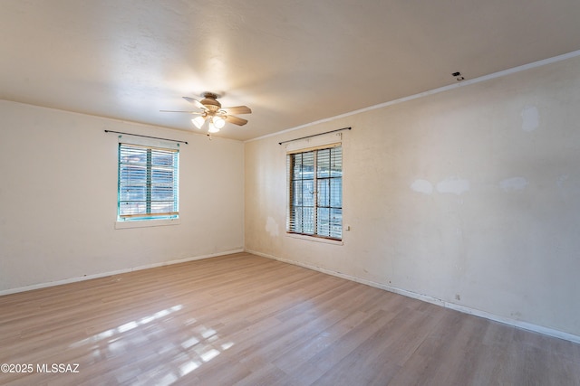 unfurnished room featuring baseboards, wood finished floors, a ceiling fan, and crown molding