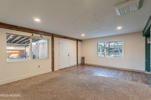 carpeted spare room featuring recessed lighting, baseboards, and wood finished floors