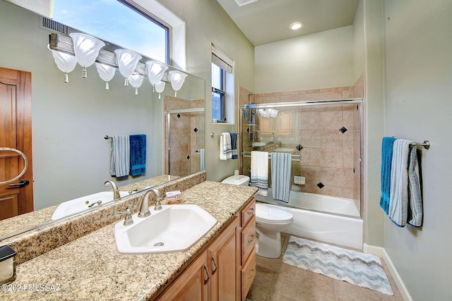 bathroom with tile patterned floors, toilet, shower / bath combination with glass door, baseboards, and vanity