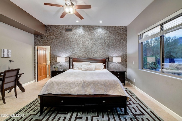 bedroom with light tile patterned floors, baseboards, visible vents, recessed lighting, and an accent wall