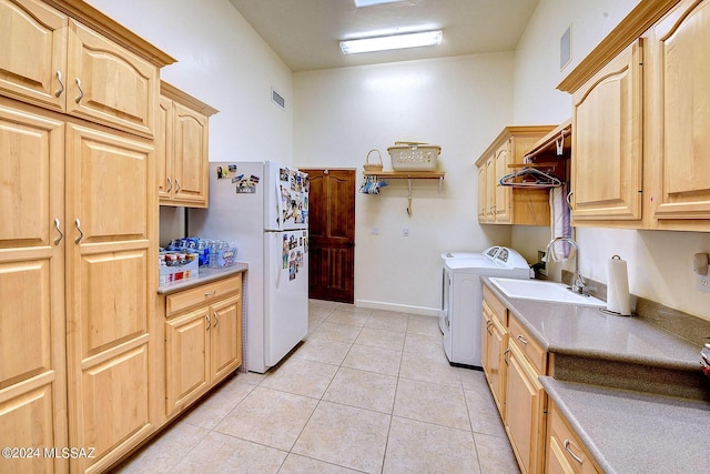 washroom featuring light tile patterned floors, visible vents, washing machine and clothes dryer, cabinet space, and a sink