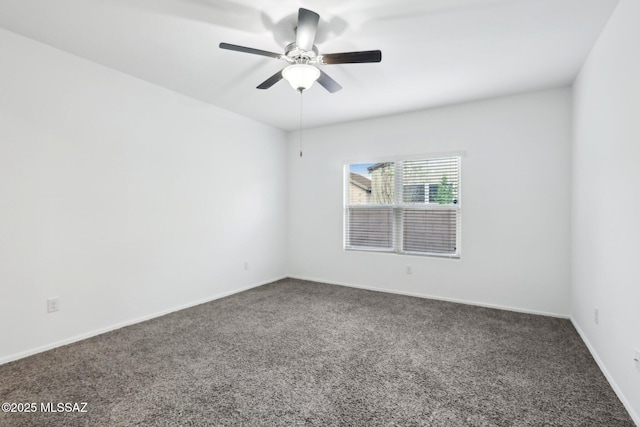 carpeted spare room featuring baseboards and ceiling fan