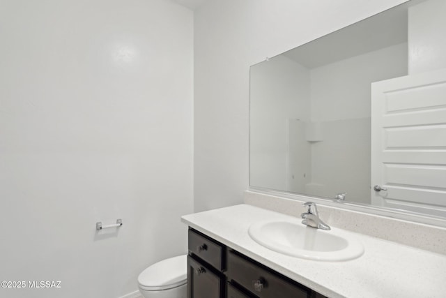 bathroom with baseboards, toilet, and vanity