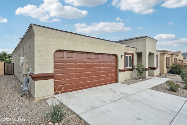 adobe home featuring stucco siding, a garage, and concrete driveway