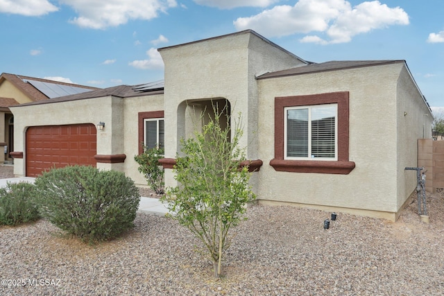 mediterranean / spanish house featuring roof mounted solar panels, stucco siding, and an attached garage