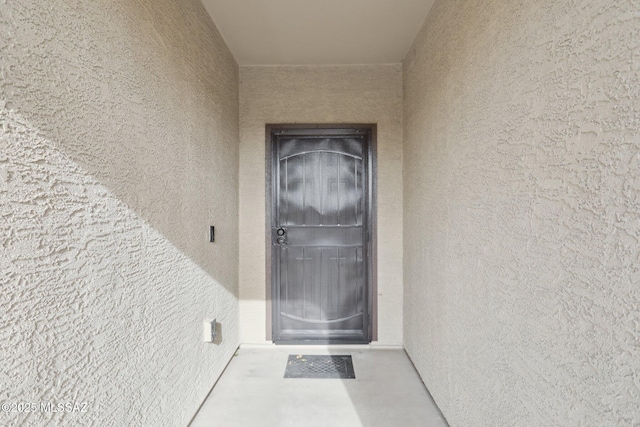 view of exterior entry with stucco siding