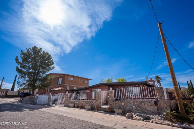 view of front of home with a fenced front yard and a gate