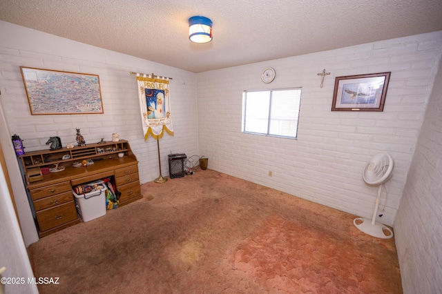 interior space with brick wall, carpet, and a textured ceiling