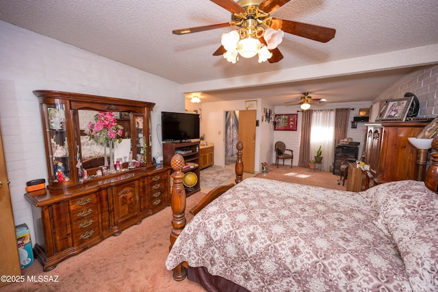 carpeted bedroom featuring ceiling fan and a textured ceiling