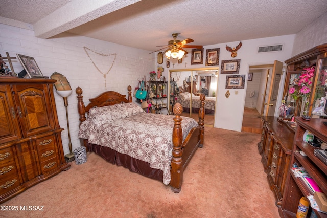 bedroom with light colored carpet, visible vents, brick wall, and a textured ceiling