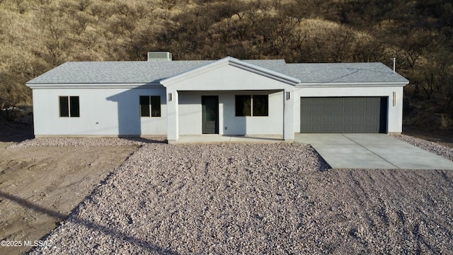 view of front of property with stucco siding, concrete driveway, and a garage
