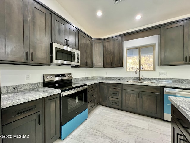 kitchen with dark brown cabinetry, light stone counters, recessed lighting, stainless steel appliances, and a sink