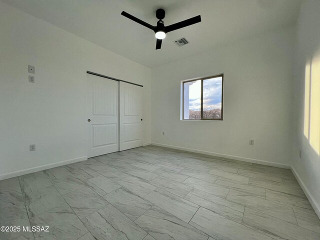 unfurnished bedroom featuring baseboards, visible vents, ceiling fan, a closet, and marble finish floor