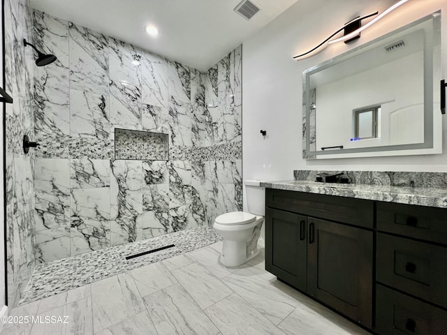 full bathroom with a marble finish shower, visible vents, toilet, and vanity