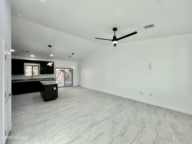 kitchen with visible vents, a kitchen island, ceiling fan, open floor plan, and vaulted ceiling