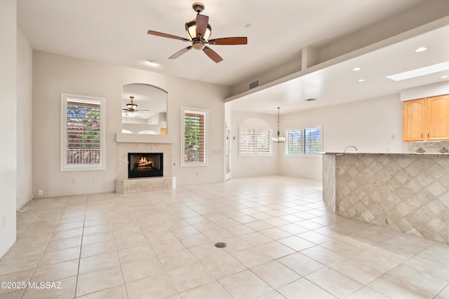 unfurnished living room featuring visible vents, light tile patterned flooring, ceiling fan, recessed lighting, and a tile fireplace
