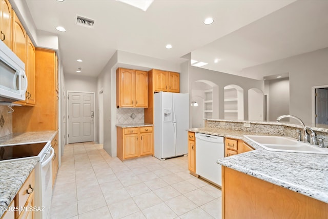 kitchen with backsplash, visible vents, a sink, recessed lighting, and white appliances