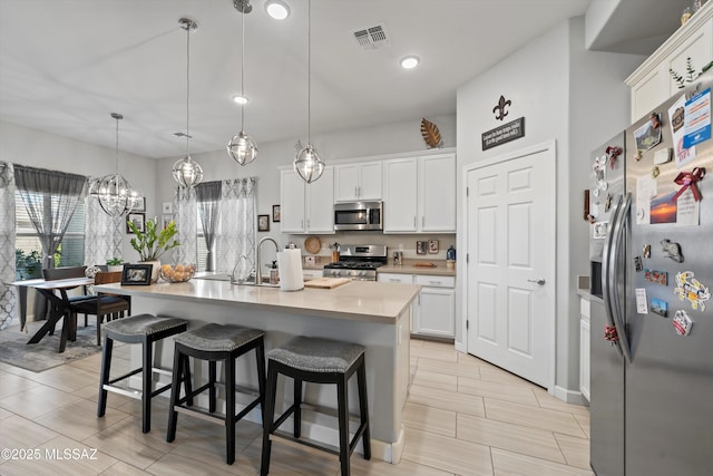 8874 W Saguaro Skies Rd, Marana, AZ 85653 - kitchen featuring stainless steel appliances, light countertops, a kitchen breakfast bar, white cabinets, and a chandelier