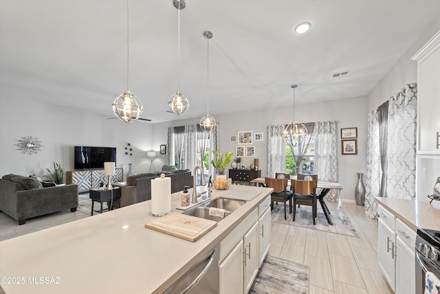 8874 W Saguaro Skies Rd, Marana, AZ 85653 - kitchen featuring a chandelier, a sink, stainless steel appliances, light countertops, and white cabinetry