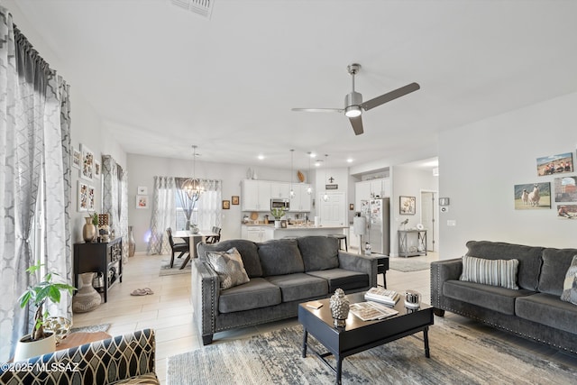 8874 W Saguaro Skies Rd, Marana, AZ 85653 - living room featuring a chandelier, ceiling fan, and light wood-type flooring