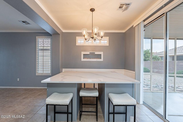 dining room featuring a notable chandelier, visible vents, light tile patterned floors, and ornamental molding