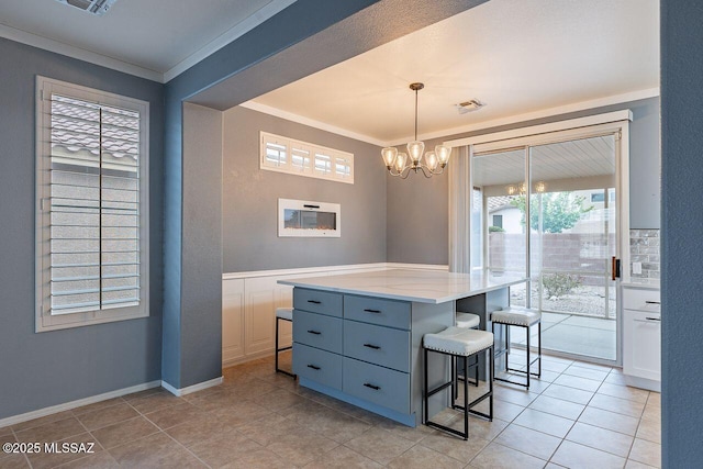 dining room featuring visible vents, crown molding, light tile patterned floors, wainscoting, and a notable chandelier