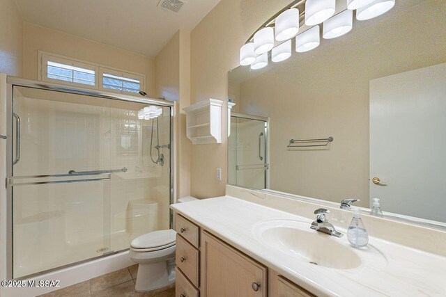 bathroom featuring tile patterned floors, toilet, visible vents, and a stall shower