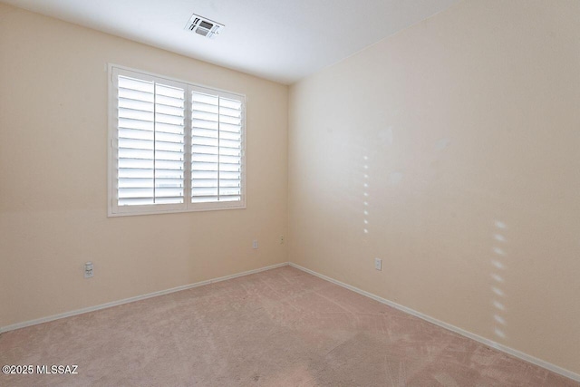empty room with visible vents, baseboards, and light colored carpet