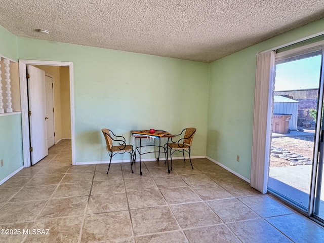 dining area featuring baseboards and a textured ceiling