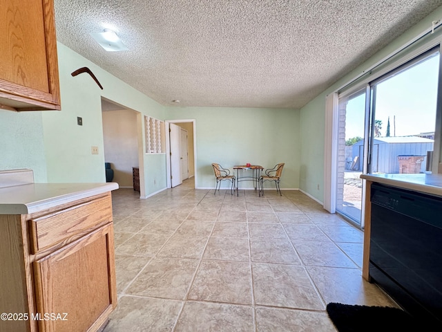 dining space featuring light tile patterned floors, baseboards, and a textured ceiling
