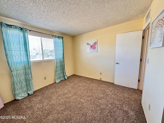 unfurnished bedroom featuring carpet floors, a textured ceiling, and visible vents