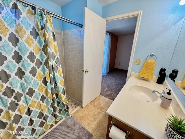 full bath featuring vanity, tile patterned floors, and tiled shower