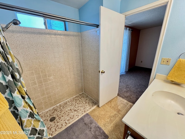 full bathroom with vanity, tile patterned flooring, and a tile shower