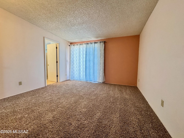 carpeted empty room featuring a textured ceiling
